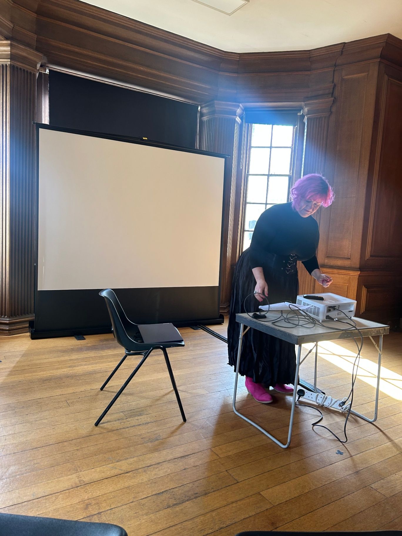 Belinda Warburton setting up a projector before delivering a talk.